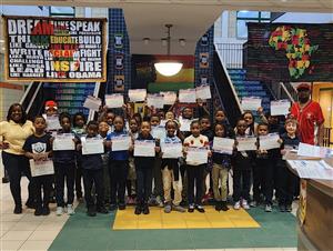 Elementary students standing and holding certificates